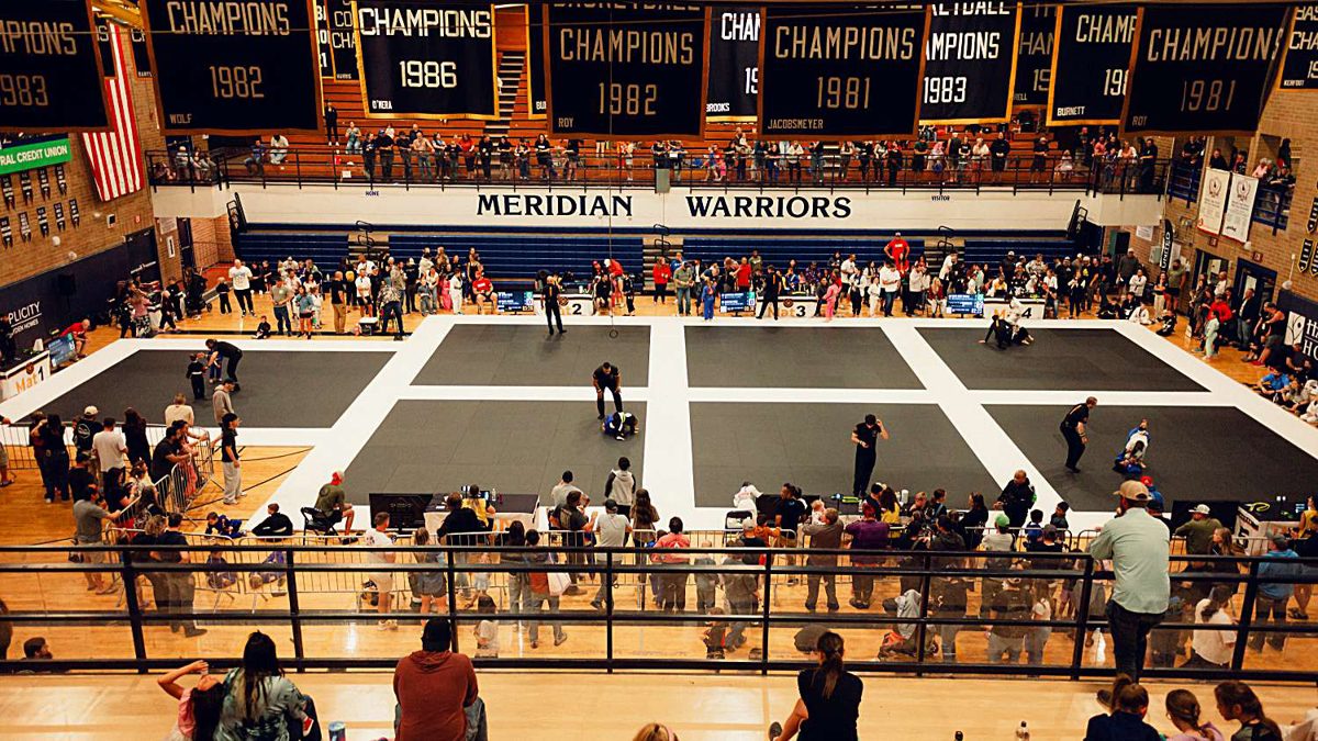 Wide view of the full competition floor and packed bleachers
